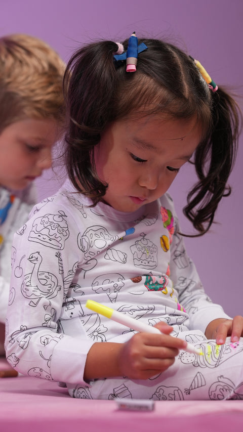 A child in Henry The Goose pajama coloring on her pants. 