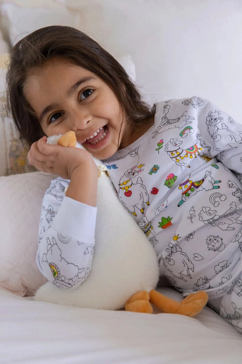 A joyful girl laughing and hugging her plush Henry the Goose toy, wearing matching Henry the Goose pajamas filled with colorful designs.